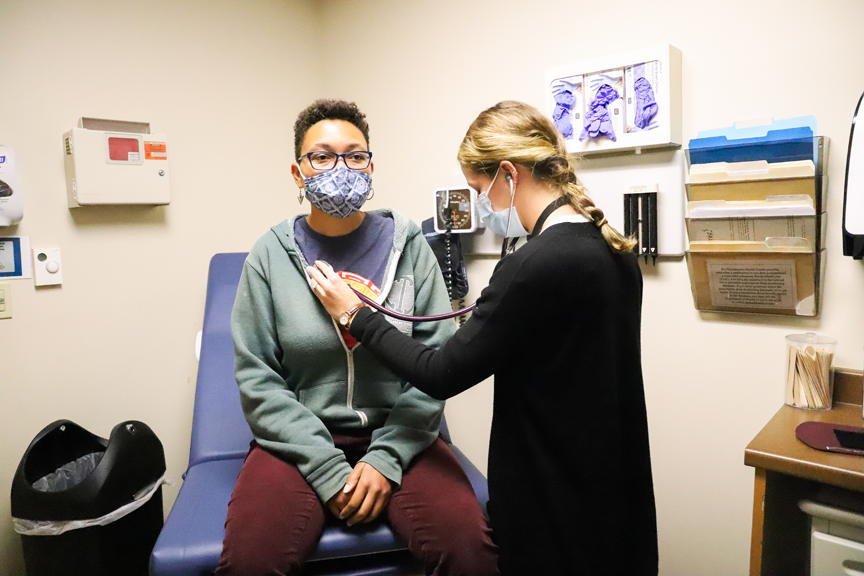 Provider checking the heart of a patient.