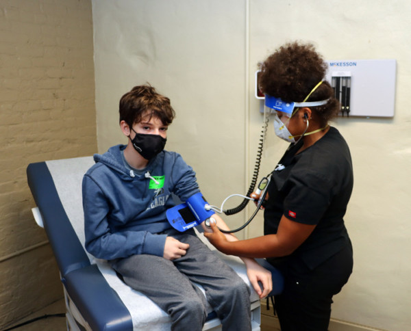 Provider-with-Child-Patient-Ceseley-Barbosa-with-Patient-Nathen-Ramos Adult provider caring for a young patient.