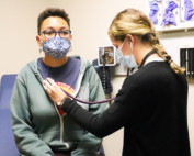 Provider checking the heartbeat of a patient.