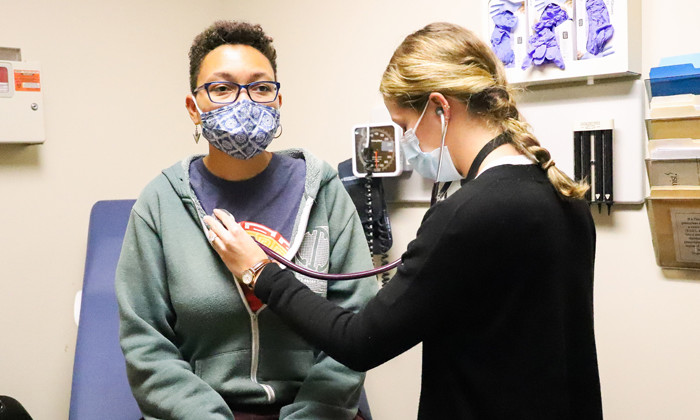 Provider checking the heartbeat of a patient.